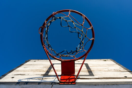 The bottom-up view of the basketball hoop against the backdrop of a mole is a blue winter sky