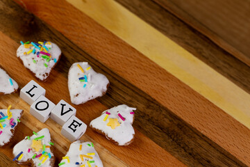 A composition of glazed gingerbreads in the shape of hearts and the word 