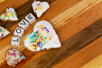 A composition of glazed gingerbreads in the shape of hearts and the word 