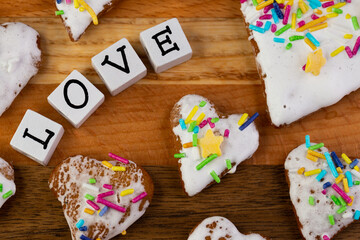 A composition of glazed gingerbreads in the shape of hearts and the word 