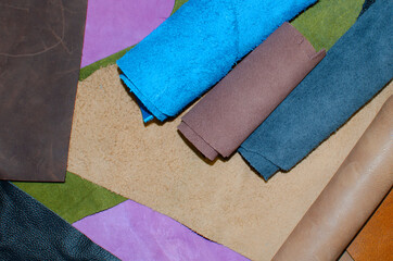 Various pieces of leather in rolls. Pieces of colored leather. View from above.