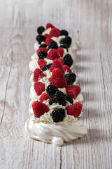 Pavlova cake. The cakes are on a wooden table. Sweet Dessert. A treat for guests. Dessert for the holiday. Cake decorated with berries.