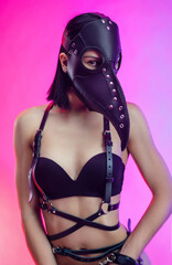 a woman in a doctor plague mask on leather belts and BDSM belts
