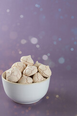 meringues in a bowl on a purple background