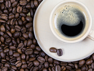 a cup of coffee on the background of coffee beans. View from above
