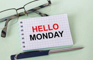 Text Hello Monday on business card with eyeglasses and pen