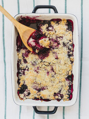Berry crumble baked in a clay rectangular shape. Light background.