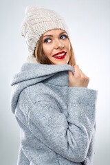 portrait of smiling woman in warm winter clothes looking up.