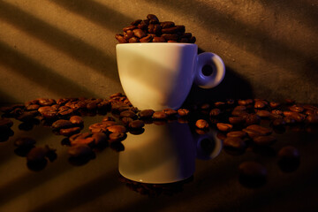 Taza de café expresso con granos de cafe. La luz de la mañana entra por la ventana