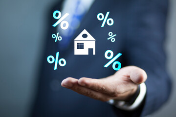 man holds a house and a percent sign
