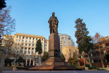 Fototapeta premium Baku, Azerbaijan - January 2, 2021 - View of Neoclassic Monolith residential building and Nizami Ganjavi Monument in Baku.
