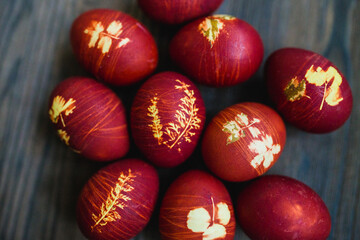 Red Easter eggs dyed with onion peels with a pattern of grass leaves and threads.
Traditions and Christianity.