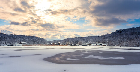 Winter panorama with windmills and frozen lake in a cloudy cold day