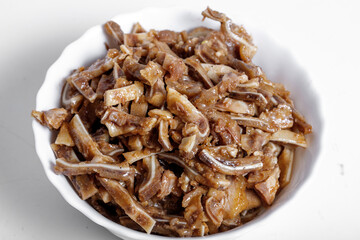 Appetizing beer snack - smoked pork pig ears on a board on a gray background