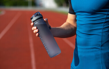 Sporty guy holding water bottle