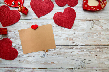 red valentine hearts with a card for text on a wooden background. valentines day concept