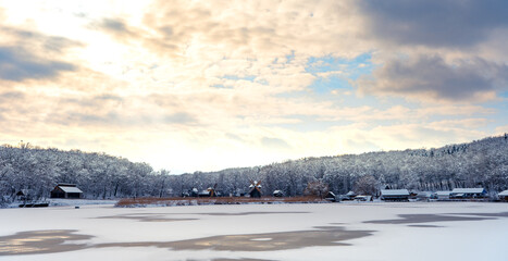 Obraz premium Winter panorama with windmills and frozen lake in a cloudy cold day