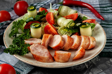 Fried homemade sausage with fresh vegetables on a platter