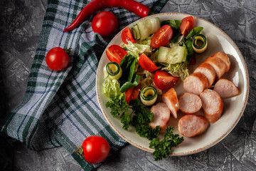 Fried homemade sausage with fresh vegetables on a platter