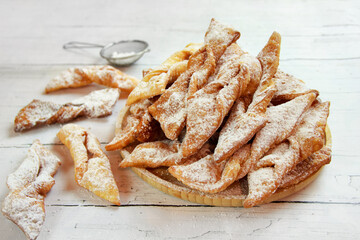 Faworki (angel wings) sprinkled with powdered sugar - traditional Polish carnival delicacy - obrazy, fototapety, plakaty