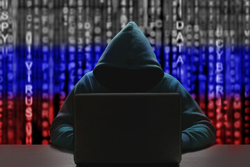 Unknown Russian hacker in a hood against the background of a binary code in the color of the flag...