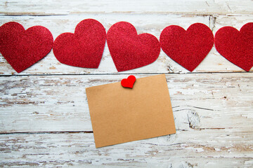 red valentine hearts with card for text on a wooden background. valentine's day. top view
