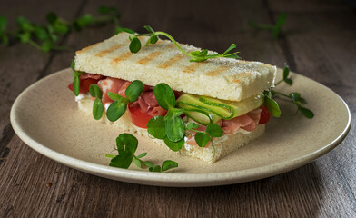 sandwich with meat, cucumber, tomato and microgreens