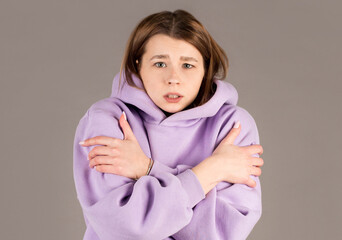 Half-length portrait of freezing woman , isolated on gray