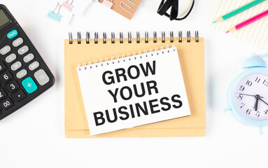 Grow your business words on office table with computer, coffee, notepad, smartphone and digital tablet