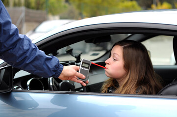 drink and drive crashed young female driver being subject to test for alcohol content with use of...