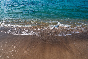 Seascape. Waves running on the sandy shore. Shore of the sea or ocean on a nice day. Vacation and relaxation by the sea.