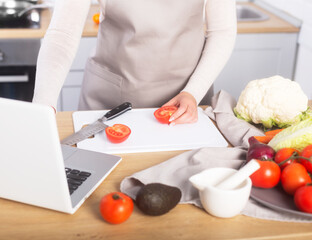 Obraz na płótnie Canvas Woman is cooking watching virtual culinary class