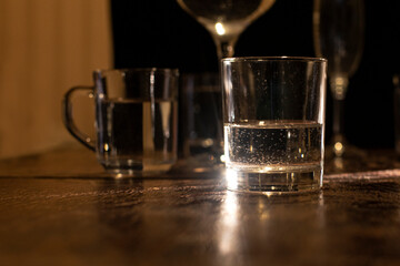 against a dark background glass with liquid reflects light