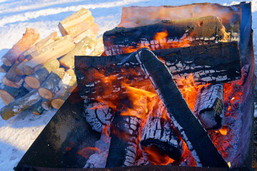 Firewood is burning. A place to keep warm in winter. Winter gathering place.