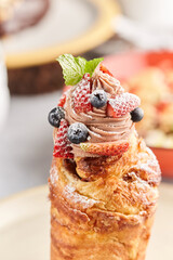 Cruffin dessert on plates panettones with icing berries and flowers cruffins with sugar and almonds...