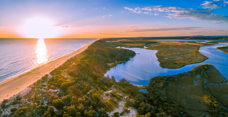 Sunset over ocean beach and river in Australia - aerial panorama