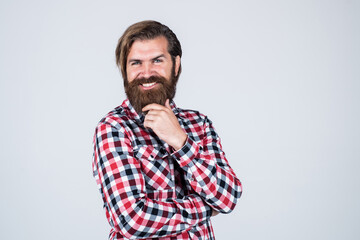 Obraz premium love my style. Handsome bearded man in casual clothes smiling. Cheerful Caucasian Man. brutal bearded hipster. male wearing checkered shirt. casual male fashion. barbershop