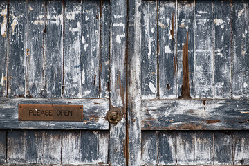 Beautiful rustic door closeup with sign saying please open