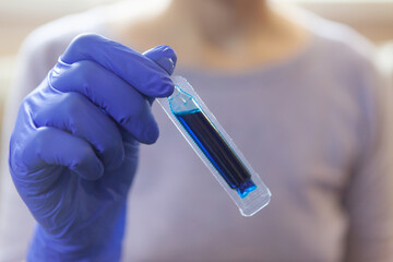 Close-up. Woman holding blue dye for easter eggs in her hand