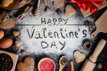 Fototapeta na wymiar Happy Valentines Day written on flour. Gingerbread cookies, spices, coffee beans, baking supplies on black wood surface