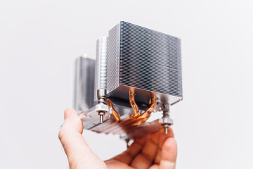 POV male hand holding computer heatsink showing hero object of modern steel cooling device for...