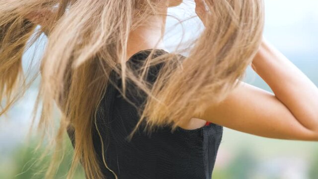 Closeup of long female hair waving on light wind outdoors.