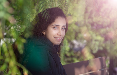 Naklejka premium young girl sitting on a park bench