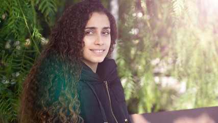 Naklejka premium young girl sitting on a park bench