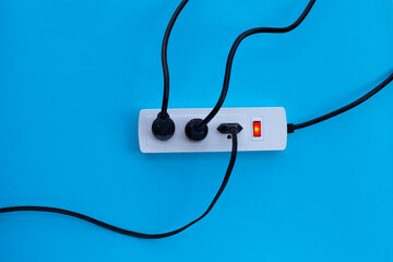 Plug in full power outlet on blue background. Top view