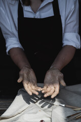 I need to wash my hands. Close up picture of female ceramic artist arms in clay after making pottery.