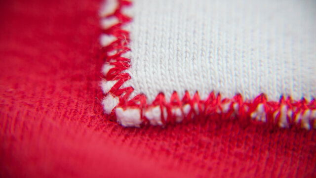 Borde de parche blanco con pespunte  de hilo rojo en tejido rojo