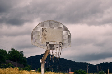 Metal basketball baskets abandoned in nature surrounded by forests