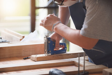 Entrepreneur  Woodwork holding a Tacker to assemble the wood pieces as the customer ordered