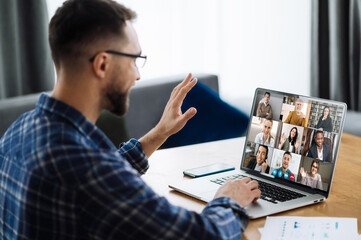 Video call, online business meeting, briefing. Successful caucasian freelancer waving hand and greeting colleagues during video conference. Distant work, online learning